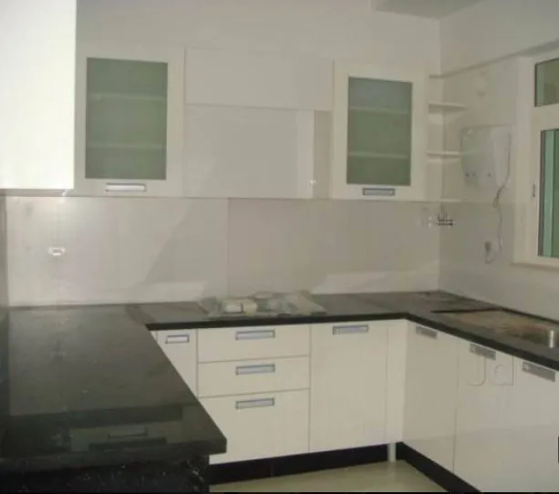 L-Shaped Modular Kitchen with Wood Grain Finish & Circular Accent Design Modular Kitchen Desk and Decor 
