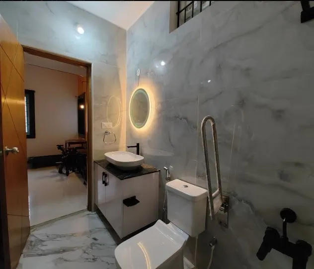 Bathroom with Marble Cladding & Backlit Circular Mirror